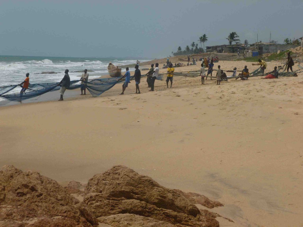 mindestens 30 Männer ziehen das schwere Netz aus dem Meer