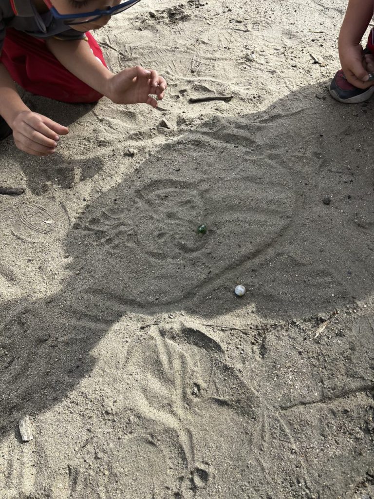 Kinder beim Murmel spielen